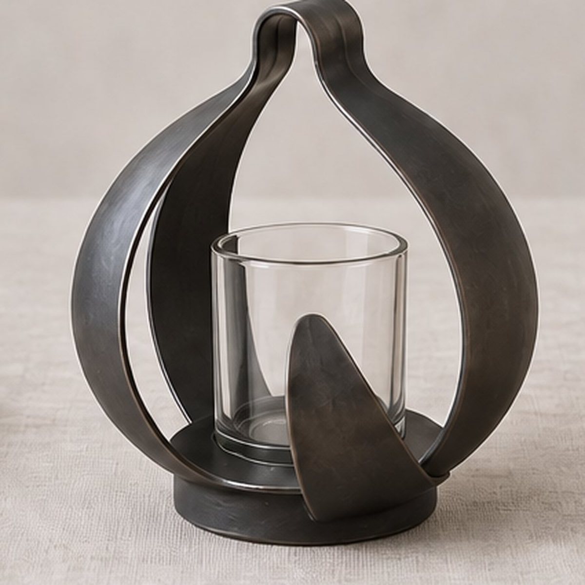Open-Rind Table Lantern — iron lantern built from open rind strips around a clear glass candle vessel, charcoal finish, concept render